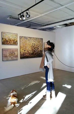 Une femme avec un casque de VR sur la tête dans une galerie d'art