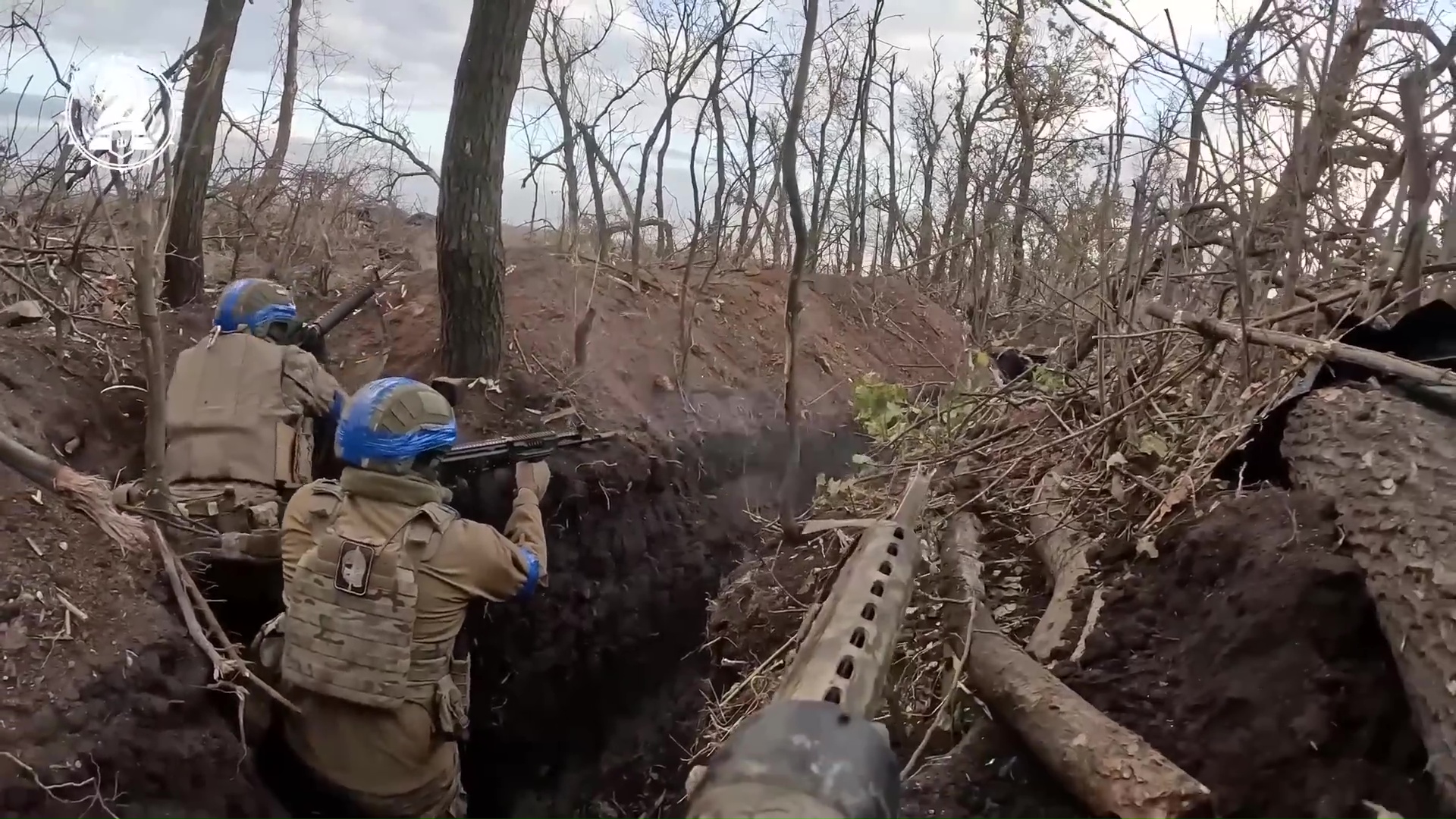 Trois soldats dans une tranchée, deux de dos, et un en vue subjective.