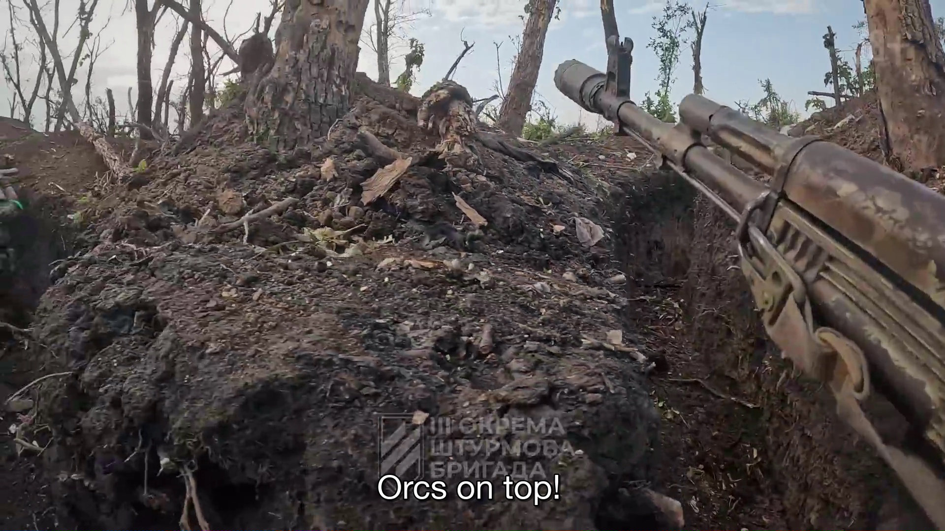 Point de vue subjectif sur une tranchée en terre. Le canon d'une mitrailleuse apparaît sur la droite.