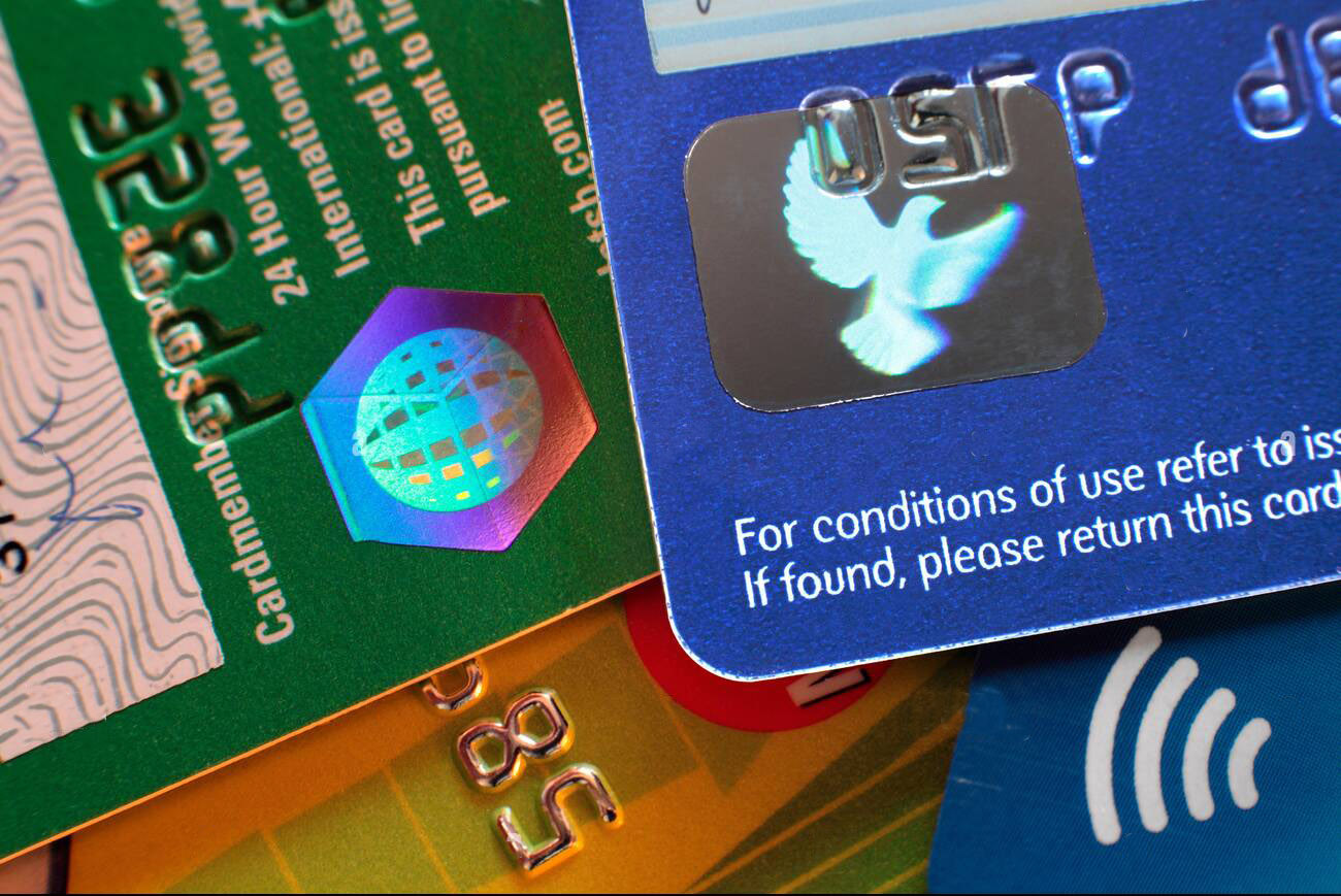 Deux hologrammes sur des cartes bancaires : un oiseau qui déploie ses ailes, et une sphère.