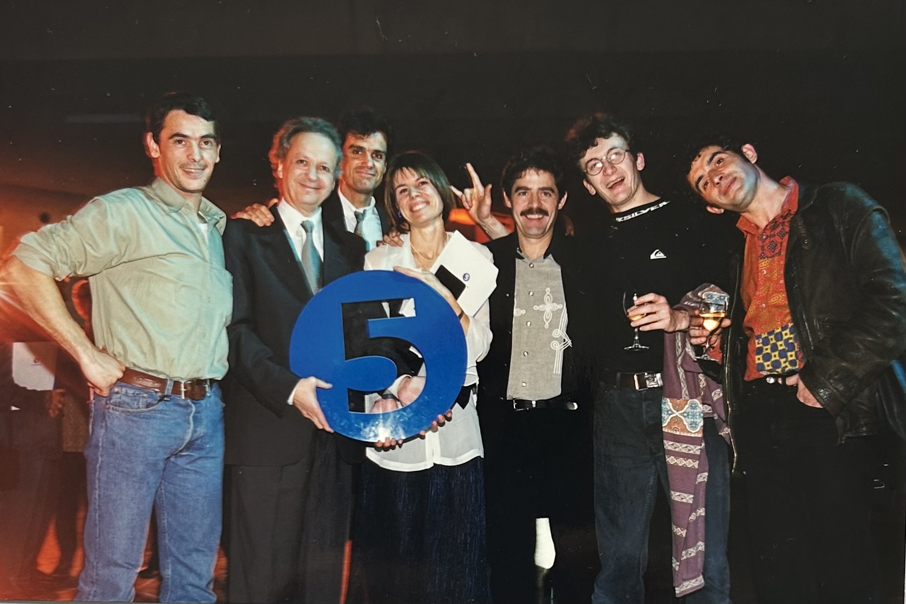 De gauche à droite, Pascal Casas, cadreur Sourd, Jean-Marie Cavada (le logo de la chaîne, un cinq évidé sur fond bleu, entre les mains), Daniel Abbou, présentateur Sourd, Jacques Sangla, réalisateur Sourd, Pascal Jobet, assistant réalisateur Sourd, et Philippe Congard, entendant, responsable du doublage voix.